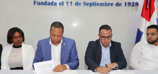 Momento en el que el director ejecutivo de Pro Consumidor, Eddy Alcántara, y el presidente de la Cámara de Comercio de San Cristóbal, Víctor Ramón Montás Pimentel, firman el convenio.