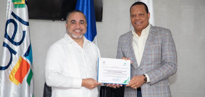 El director ejecutivo de Pro Consumidor, Eddy Alcántara, a la derecha, junto al subdirector del INAP, Ángel Familia, en momento de la entrega del certificado de exaltación.